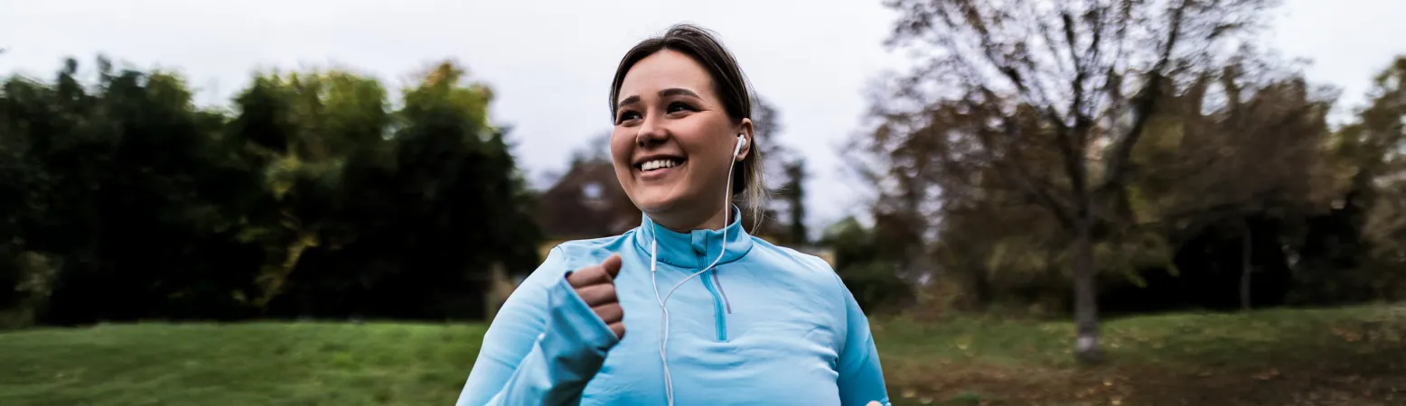 Junge Frau beim Joggen im Park – kurze Trainingseinheiten steigern Ausdauer und unterstützen die Lebergesundheit effektiv